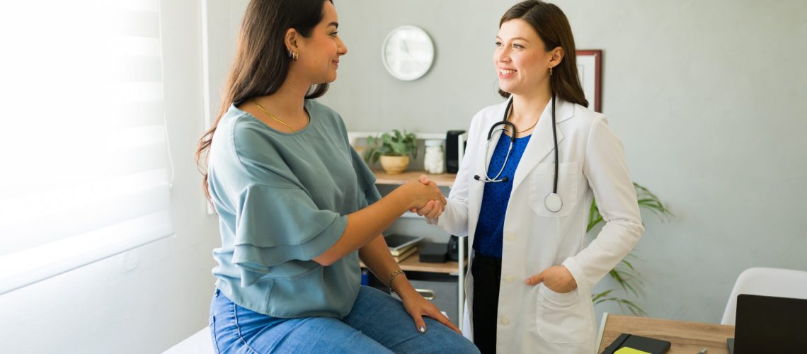 Female,Doctor,Happily,Shaking,Hands,With,Her,Hispanic,Patient,After